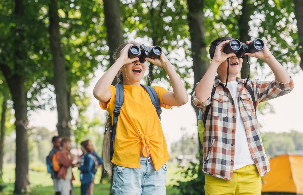 Children observing nature through binoculars 