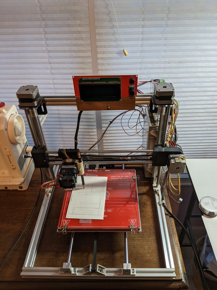 A look down at the print bed of a 3D printer as it actively works on creating a project.