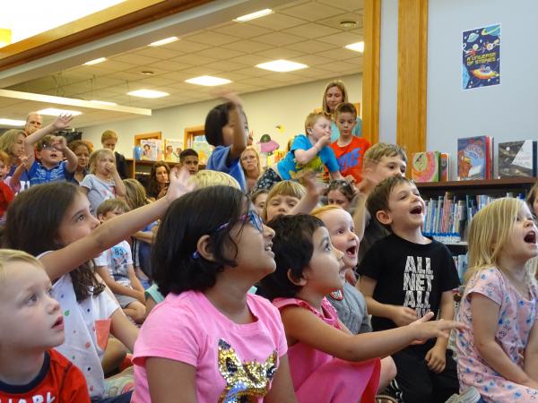  a diverse array of kids excited about a program at the library